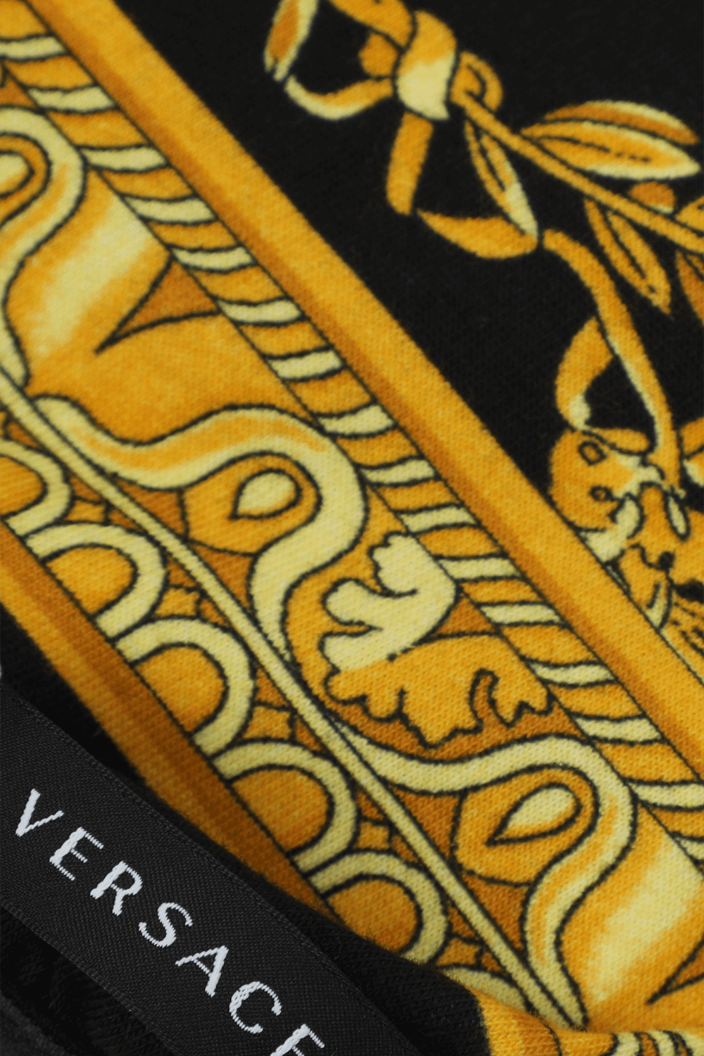 תמונת תקריב של חולצה לכלב בפרינט לוגומאני VERSACE