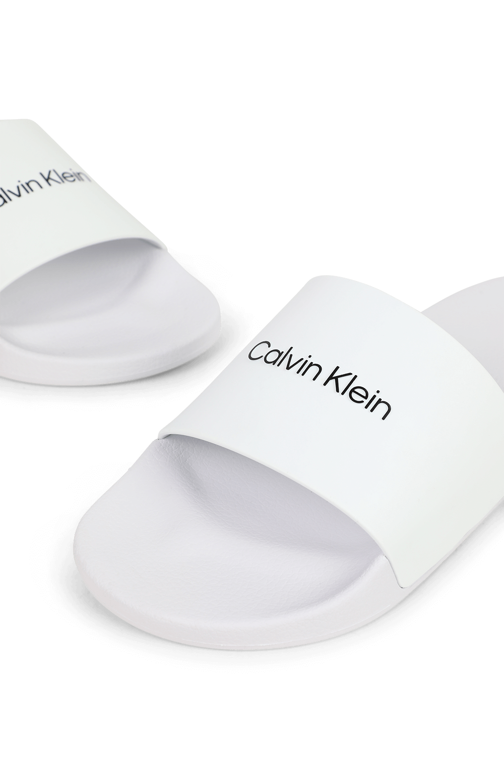 תמונת תקריב של כפכפי סליידס לבנים CALVIN KLEIN